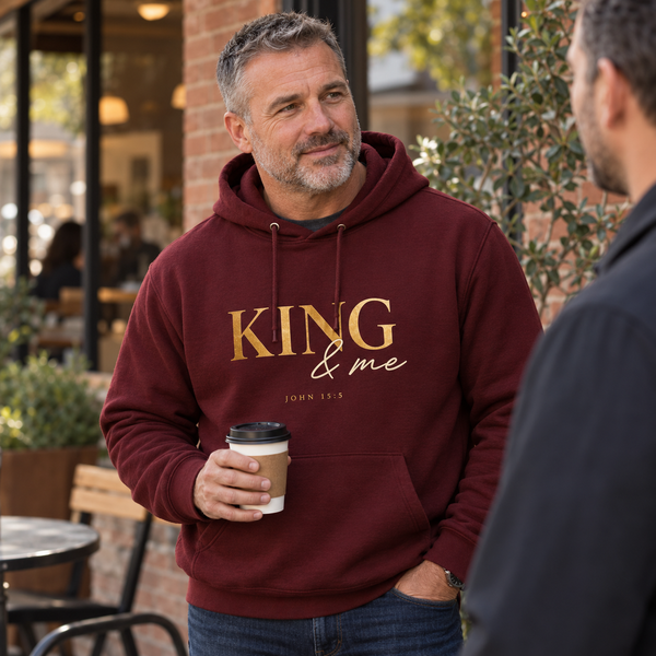 A mature man wearing the New Horizon Unplugged KING and Me hoodie in a natural conversation