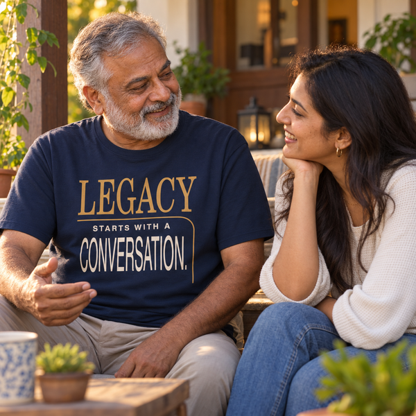 A South Asian grandfather wearing the New Horizon Unplugged Legacy T-shirt while speaking with his granddaughter