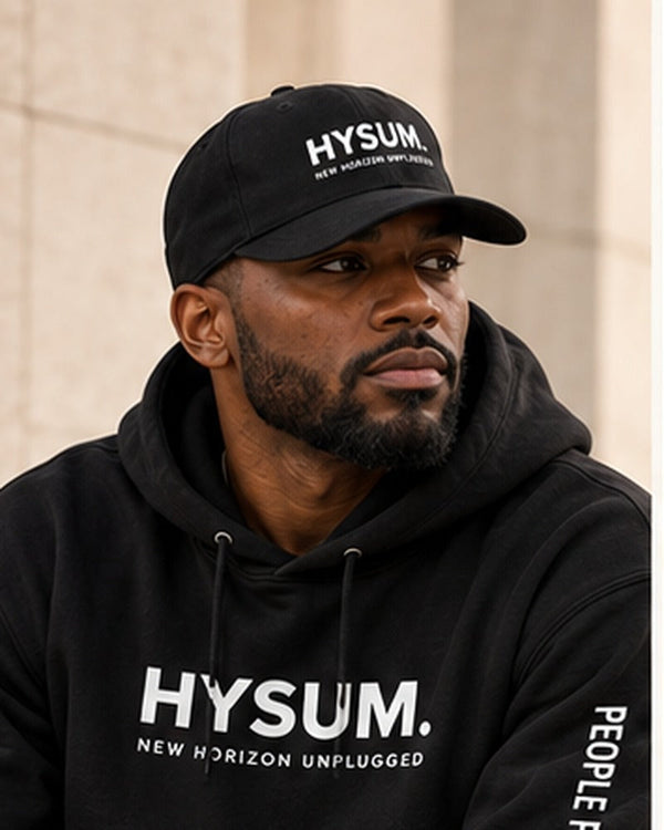 New Horizon Unplugged male model wearing black HYSUM hoodie with full face and cap visible